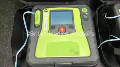 2 x Zoll AED PRO Defibrillators with 2 x 3 Lead ECG Leads, 3 x Electrode Packs *All Out of Date* in 2 x Carry Bags (Both Power Up with Stock Battery, Batteries Not Included, Slightly Damaged Display Screens) - 2