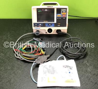 Medtronic Lifepak 20 Defibrillator / Monitor Including ECG and Printer Options with 1 x Paddle Lead, 1 x 4 Lead ECG Lead, 1 x 6 Lead ECG Lead and 1 x Electrode Pack *Expired* (Powers Up with Missing Door Panel and Missing Button - See Photos)