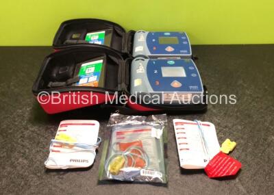 2 x Philips Heartstart FR2+ Defibrillators with 1 x Philips M3863A Battery and 3 x Heartstart Adult Training Pads in Carry Cases (Both Power Up and Pass Self Test) *SN 0307227775 / 0307228011*