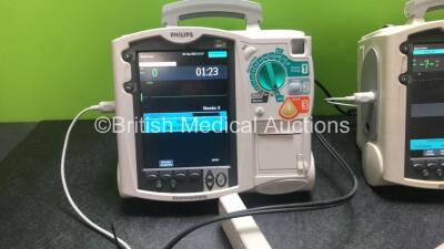 2 x Philips Heartstart MRx Defibrillators Including Pacer, ECG and Printer Options with 2 x Philips M3539A Modules, 2 x Philips M3538A Batteries, 2 x Paddle Leads, 2 x Philips M3725A 50 Ohm Test Loads and 2 x 3 Lead ECG Leads (Both Power Up) *SN US0031538 - 2