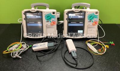 2 x Philips Heartstart MRx Defibrillators Including ECG and Printer Options with 2 x Philips M3539A Modules, 2 x Philips M3538A Batteries, 2 x Paddle Leads, 2 x Philips M3725A 50 Ohm Test Loads and 2 x 3 Lead ECG Leads (Both Power Up) *SN US00318529 / US0