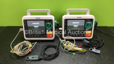 2 x Philips Efficia DFM100 Defibrillators *Mfd - 2019 / 2019* with ECG and Printer Options Including 2 x 3 Lead ECG Leads, 2 x Paddle Leads and 2 x Philips Rechargeable Li-ion Battery Packs (Both Power Up)