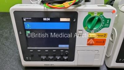 2 x Philips Heartstart XL+ Defibrillators Including PACER, ECG and Printer Options with 2 x Philips M1674A 3 Lead ECG Lead, 2 x Philips Battery Ref 989803167281 and 2 x Paddle Lead (Both Power Up) *SN US4142206 / USN159054* - 3