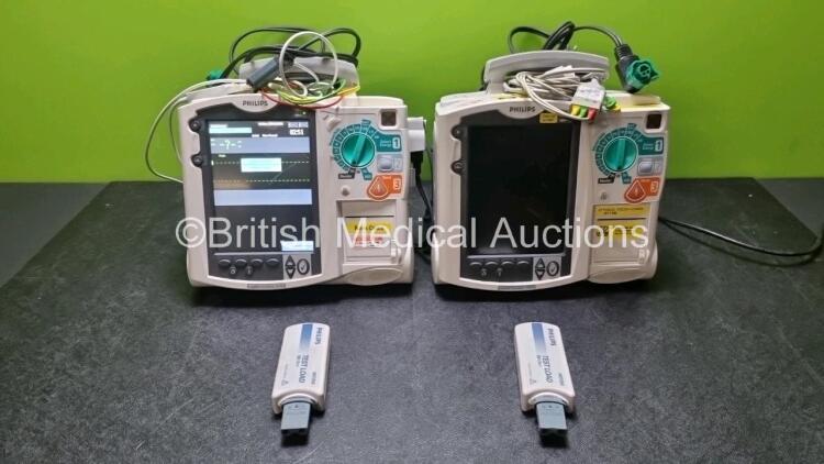 2 x Philips Heartstart MRx Defibrillators / Monitors Including ECG and Printer Options with 2 x Paddle Leads, 2 x Philips M3725A Test Loads, 2 x 3 Lead ECG Leads and 2 x Philips M3539A Modules (Both Power Up) *SN US00576155 / US00576154*