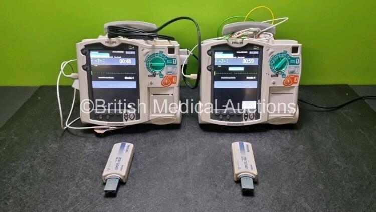 2 x Philips Heartstart MRx Defibrillators / Monitors Including ECG and Printer Options with 2 x Paddle Leads, 2 x Philips M3725A Test Loads, 2 x ECG Lead Connectors and 2 x Philips M3539A Modules (Both Power Up) *SN US00584968 / US00581612*