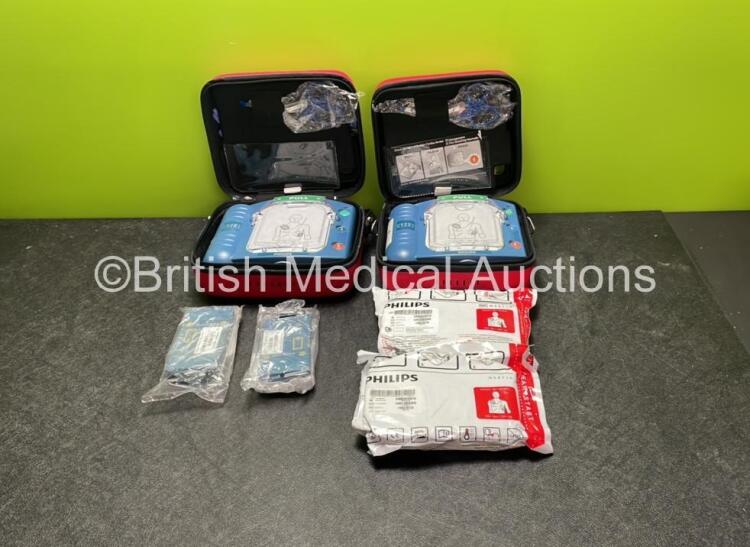 2 x Philips Heartstart HS1 Defibrillators with 4 x Batteries and 4 x Philips REF M5071A Defibrillator Pads *2 Unused* in Carry Cases (Both Power Up)