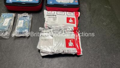 2 x Philips Heartstart HS1 Defibrillators with 4 x Batteries and 4 x Philips REF M5071A Defibrillator Pads *2 Unused* in Carry Cases (Both Power Up) - 4