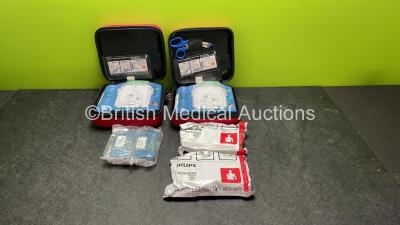 2 x Philips Heartstart HS1 Defibrillators with 4 x Batteries and 4 x Philips REF M5071A Defibrillator Pads *2 Unused* in Carry Cases (Both Power Up)