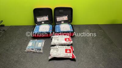 2 x Philips Heartstart HS1 Defibrillators with 4 x Batteries and 4 x Philips REF M5071A Defibrillator Pads *2 Unused* in Carry Cases (Both Power Up)