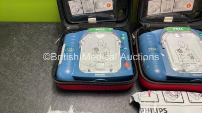 2 x Philips Heartstart HS1 Defibrillators with 4 x Batteries and 4 x Philips REF M5071A Defibrillator Pads *2 Unused* in Carry Cases (Both Power Up) - 2