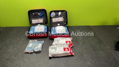 2 x Philips Heartstart HS1 Defibrillators with 3 x Batteries and 4 x Philips REF M5071A Defibrillator Pads *2 Unused* in Carry Cases (Both Power Up)