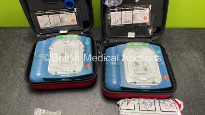 2 x Philips Heartstart HS1 Defibrillators with 3 x Batteries and 4 x Philips REF M5071A Defibrillator Pads *2 Unused* in Carry Cases (Both Power Up) - 2