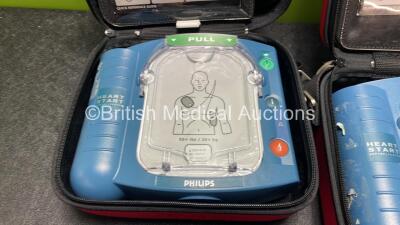 2 x Philips Heartstart HS1 Defibrillators with 3 x Batteries and 4 x Philips REF M5071A Defibrillator Pads *2 Unused* in Carry Cases (Both Power Up) - 3