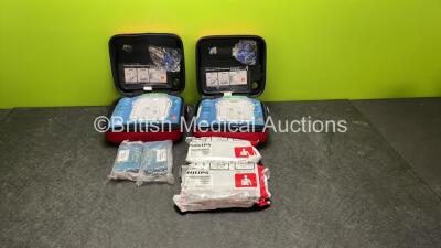 2 x Philips Heartstart HS1 Defibrillators with 4 x Batteries and 4 x Philips REF M5071A Defibrillator Pads *2 Unused* in Carry Cases (Both Power Up)