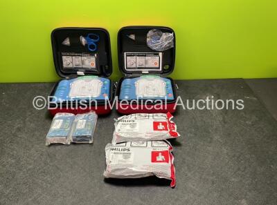 2 x Philips Heartstart HS1 Defibrillators with 4 x Batteries and 4 x Philips REF M5071A Defibrillator Pads *2 Unused* in Carry Cases (Both Power Up)