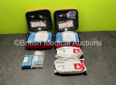 2 x Philips Heartstart HS1 Defibrillators with 4 x Batteries and 4 x Philips REF M5071A Defibrillator Pads *2 Unused* in Carry Cases (Both Power Up)