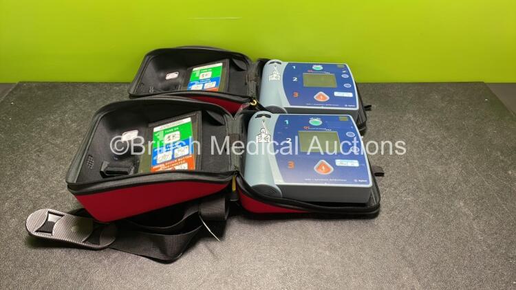 2 x Agilent Heartstream FR2 Defibrillators with 2 x Philips M3863A Batteries *Install M3863A Batteries* in 2 x Carry Case (Both Power Up and Pass Self Tests) *SN 0302056696, 0302056698*