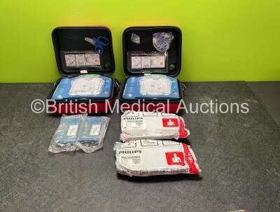 2 x Philips Heartstart HS1 Defibrillators with 4 x Batteries and 4 x Philips REF M5071A Defibrillator Pads *2 Unused* in Carry Cases (Both Power Up)