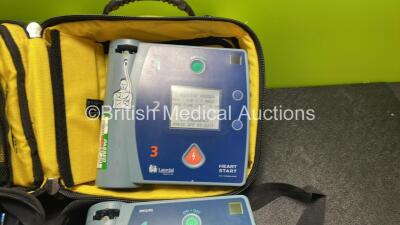 Job Lot Including 1 x Philips Heartstart FR2+ Defibrillator, 1 x Laerdal Heartstart FR2+ Defibrillator with 2 x Philips M3863A Batteries *Install Dates 04-2023, 09-2022* 4 x Philips Electrode Pads *All Out of Date* 2 x Carry Bags (Both Power Up and Passe - 2