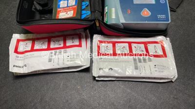 Job Lot Including 1 x Philips Heartstart FR2+ Defibrillator, 1 x Laerdal Heartstart FR2+ Defibrillator with 2 x Philips M3863A Batteries *Install Dates 04-2023, 09-2022* 4 x Philips Electrode Pads *All Out of Date* 2 x Carry Bags (Both Power Up and Passe - 4