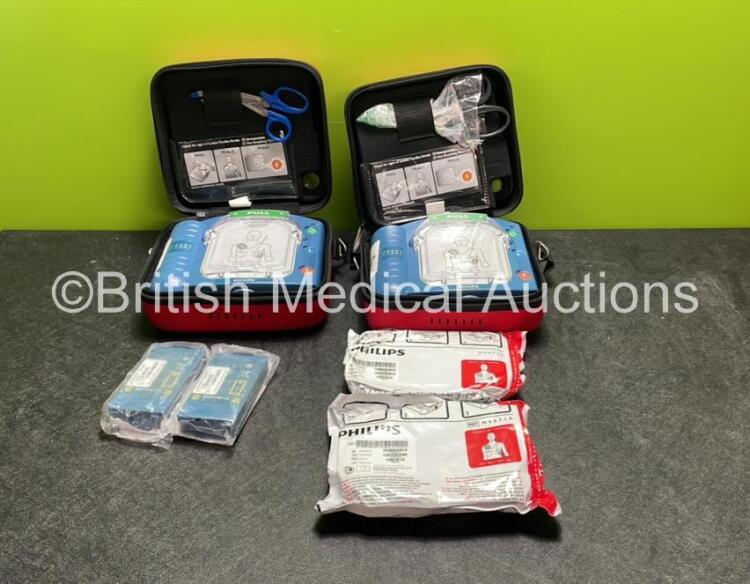 2 x Philips Heartstart HS1 Defibrillators with 4 x Batteries and 4 x Philips REF M5071A Defibrillator Pads *2 Unused* in Carry Cases (Both Power Up)