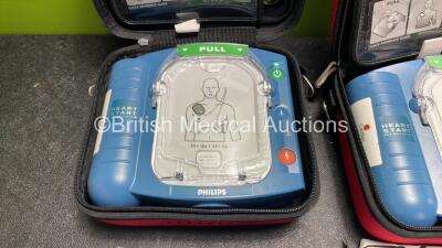 2 x Philips Heartstart HS1 Defibrillators with 4 x Batteries and 4 x Philips REF M5071A Defibrillator Pads *2 Unused* in Carry Cases (Both Power Up) - 2