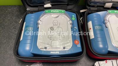 2 x Philips Heartstart HS1 Defibrillators with 4 x Batteries and 4 x Philips REF M5071A Defibrillator Pads *2 Unused* in Carry Cases (Both Power Up) - 2