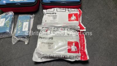 2 x Philips Heartstart HS1 Defibrillators with 4 x Batteries and 4 x Philips REF M5071A Defibrillator Pads *2 Unused* in Carry Cases (Both Power Up) - 4