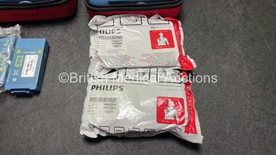 2 x Philips Heartstart HS1 Defibrillators with 4 x Batteries and 4 x Philips REF M5071A Defibrillator Pads *2 Unused* in Carry Cases (Both Power Up) - 4