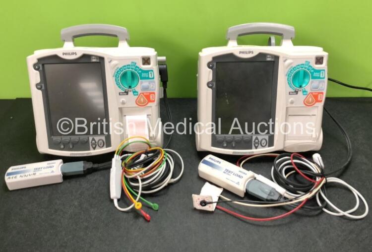 2 x Philips Heartstart MRx Defibrillators Including ECG and Printer Options with 2 x M3725A Test Loads, 2 x Paddle Leads, 2 x ECG Leads, 2 x Batteries and 1 x M33539A Module (Both Power Up then Shut Down - See Photos)