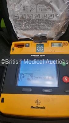 2 x Medtronic Physio Control Lifepak 1000 Defibrillators *Mfd 2021 / 2008* (Both Power Up) with 2 x 3 Lead ECG Lead , 3 x in Date Electrode Packs and 3 x Physio Control 1000 Batteries *Li/Mn02* - 3