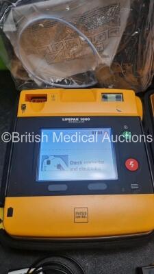 2 x Medtronic Physio Control Lifepak 1000 Defibrillators *Mfd 2021 / 2017* (Both Power Up) with 2 x 3 Lead ECG Lead , 4 x in Date Electrode Packs and 3 x Physio Control 1000 Batteries *Li/Mn02* - 3