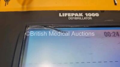 2 x Medtronic Physio Control Lifepak 1000 Defibrillators *Mfd 2008 / 2009* (Both Power Up 1 x Crack In Screen - See Photo) with 2 x 3 Lead ECG Lead , 2 x in Date Electrode Packs and 3 x Physio Control 1000 Batteries *Li/Mn02* - 3