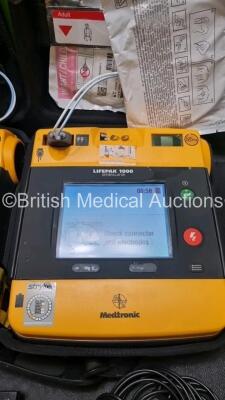 2 x Medtronic Physio Control Lifepak 1000 Defibrillators *Mfd 2008 / 2018* (Both Power Up) with 2 x 3 Lead ECG Lead , 3 x in Date Electrode Packs and 3 x Physio Control 1000 Batteries *Li/Mn02* - 2