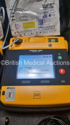 2 x Medtronic Physio Control Lifepak 1000 Defibrillators *Mfd 2017 / 2021* (Both Power Up 1 x with Marks on Screen - See Photo) with 2 x 3 Lead ECG Lead , 4 x in Date Electrode Packs and 3 x Physio Control 1000 Batteries *Li/Mn02* - 2