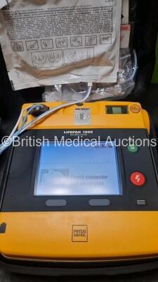 2 x Medtronic Physio Control Lifepak 1000 Defibrillators *Mfd 2019 / 2015* (Both Power Up) with 2 x 3 Lead ECG Lead and 4 x Physio Control 1000 Batteries *Li/Mn02* - 3