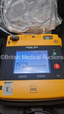 2 x Medtronic Physio Control Lifepak 1000 Defibrillators *Mfd 2016 / 2014* (Both Power Up) with 2 x 3 Lead ECG Lead , 4 x in Date Electrode Packs and 3 x Physio Control 1000 Batteries *Li/Mn02* - 2