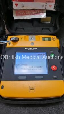 2 x Medtronic Physio Control Lifepak 1000 Defibrillators *Mfd 2016 / 2014* (Both Power Up) with 2 x 3 Lead ECG Lead , 5 x in Date Electrode Packs and 4 x Physio Control 1000 Batteries *Li/Mn02* - 2