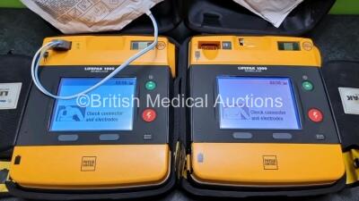 2 x Medtronic Physio Control Lifepak 1000 Defibrillators *Mfd 2014 / 2018* (Both Power Up Both with Crack In Casing - See Photos) with 2 x 3 Lead ECG Leads and 2 x Batteries *Install Before - 2024* - 2