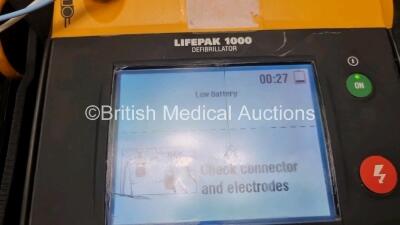 2 x Medtronic Physio Control Lifepak 1000 Defibrillators *Mfd 2010 / 2008* (Both Power Up Both with Crack In Casing and In Screen - See Photo) with 2 x 3 Lead ECG Leads and 2 x Batteries *Install Before 2024* - 6