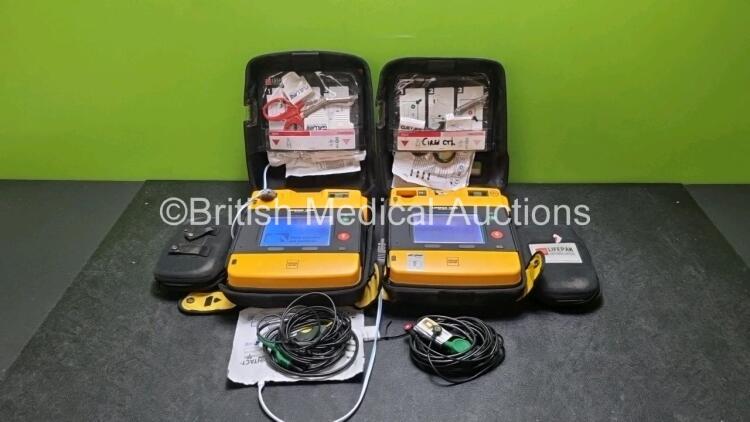 2 x Medtronic Physio Control Lifepak 1000 Defibrillators *Mfd 2012 / 2018* (Both Power Up Both with Slight Crack In Casing - See Photos) with 2 x 3 Lead ECG Leads and 2 x Batteries *Install Before 2027 / 2024*