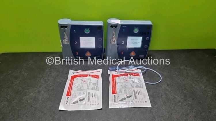 2 x Philips Heartstart FR2+ Defibrillators (Both Power Up) with 2 x Batteries and 2 x Electrode Packs