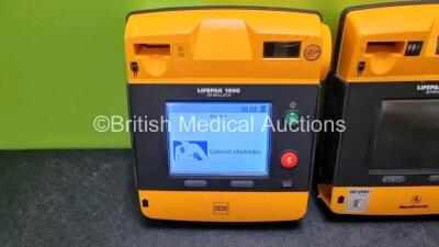 2 x Medtronic Physio Control Lifepak 1000 Defibrillators *Mfd 2016 / 2009* (Both Power Up with Stock Battery Stock Battery Not Included, Both with Damage to Casing - See Photo) - 2