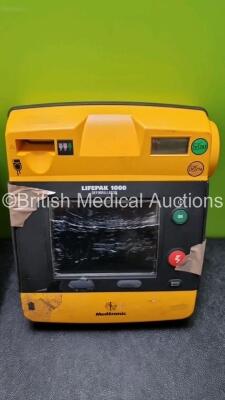 2 x Medtronic Physio Control Lifepak 1000 Defibrillators *Mfd 2009* (1 x No Power, 1 x Powers Up with Stock Battery Stock Battery Not Included, Both with Damage to Casing and Screen- See Photos) - 3