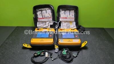 2 x Medtronic Physio Control Lifepak 1000 Defibrillators *Mfd 2008* (Both Power Up,1 x Slight Crack In Screen - See Photo) with 2 x 3 Lead ECG Leads, 5 x In Date Electrode Packs and 2 x Batteries *Install Before 2024 / 2030*