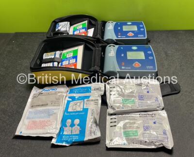 2 x Laerdal Heartstart FR2+ Defibrillators with 4 x Batteries and 4 x Electrode Packs *2 in Date, 2 Expired* in Carry Cases (Both Power Up)