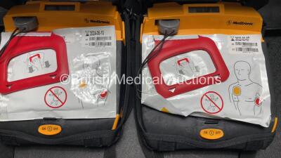 2 x Medtronic Lifepak CR Plus Defibrillators (Both Power Up) with 2 x Electrode Packs *1 x in Date, 1 x Expired* in Carry Cases and 2 x Medtronic Mounting Brackets - 5