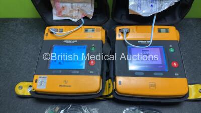 2 x Medtronic Physio Control Lifepak 1000 Defibrillators (Both Power Up with Cracks in Casing - See Photos) with 2 x 3 Lead ECG Leads, 3 x Electrode Packs (All in Date) and 2 x Batteries *Install Before 2024 / 2024* - 2