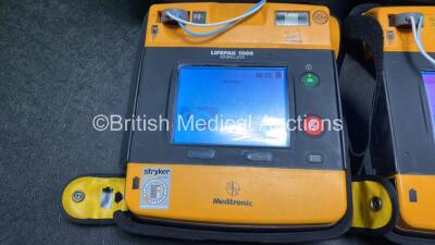 2 x Medtronic Physio Control Lifepak 1000 Defibrillators (Both Power Up with Cracks in Casing - See Photos) with 2 x 3 Lead ECG Leads, 3 x Electrode Packs (All in Date) and 2 x Batteries *Install Before 2024 / 2024* - 3