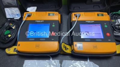 2 x Medtronic Physio Control Lifepak 1000 Defibrillators (Both Power Up with Cracks in Casing - See Photos) with 2 x 3 Lead ECG Leads, 3 x Electrode Packs (All in Date) and 2 x Batteries *Install Before 2024 / 2024* - 2